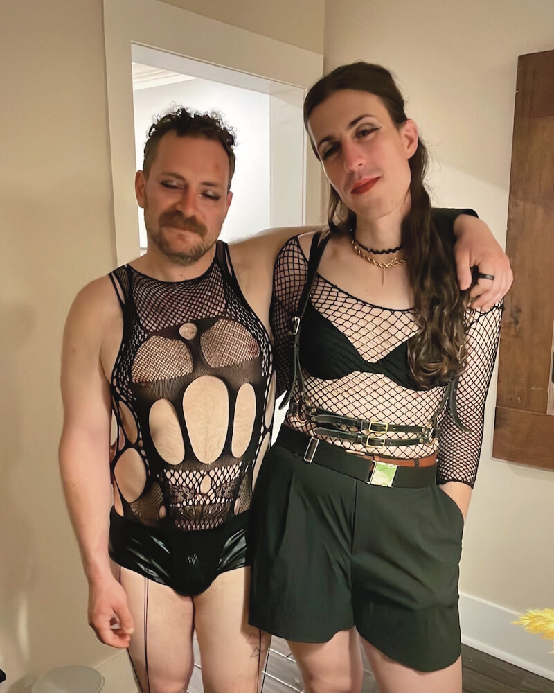 A picture of me and one of my friends. My friend has eyeliner on and he is wearing a sexy mesh top with complex patterns.